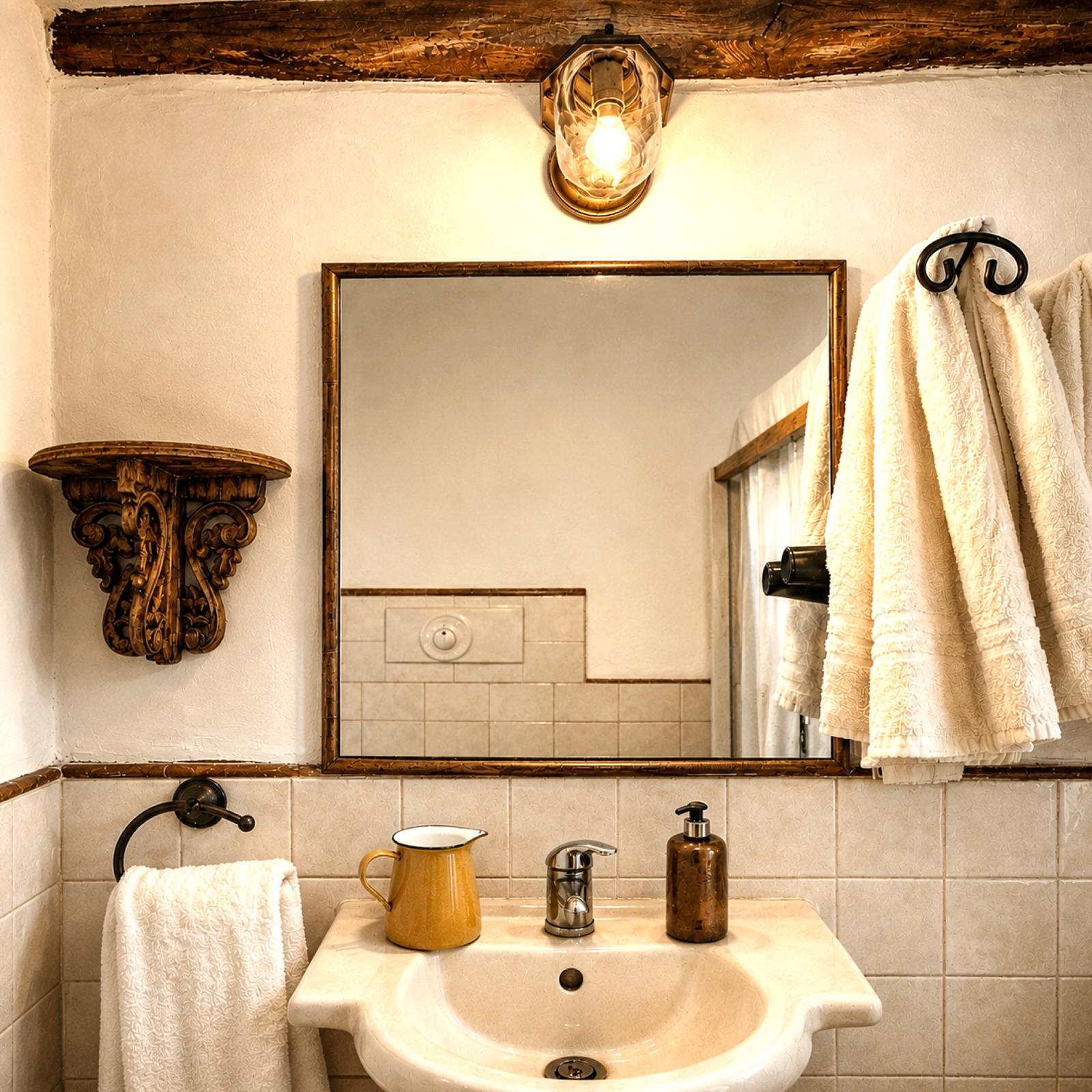 Bagno della Camera Rosa con specchio, trave a vista e asciugamani