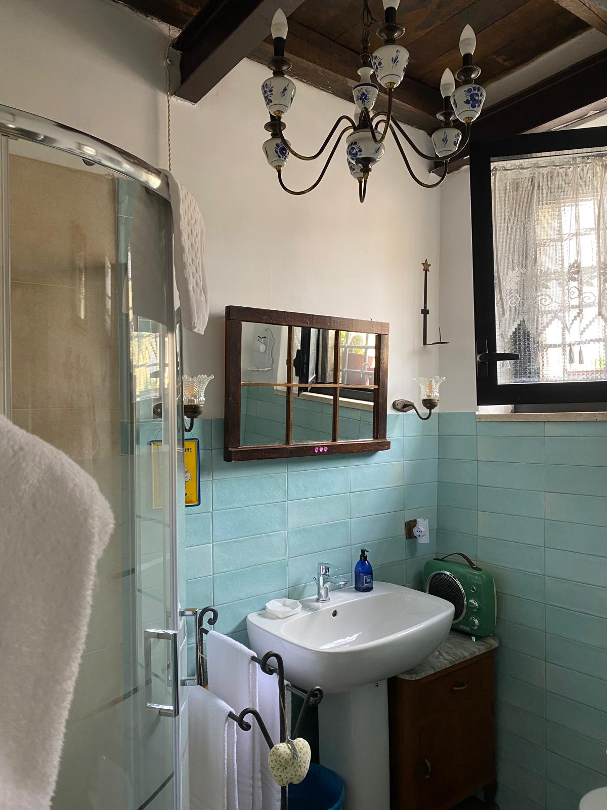 Bagno della casetta con doccia e piastrelle verde acqua