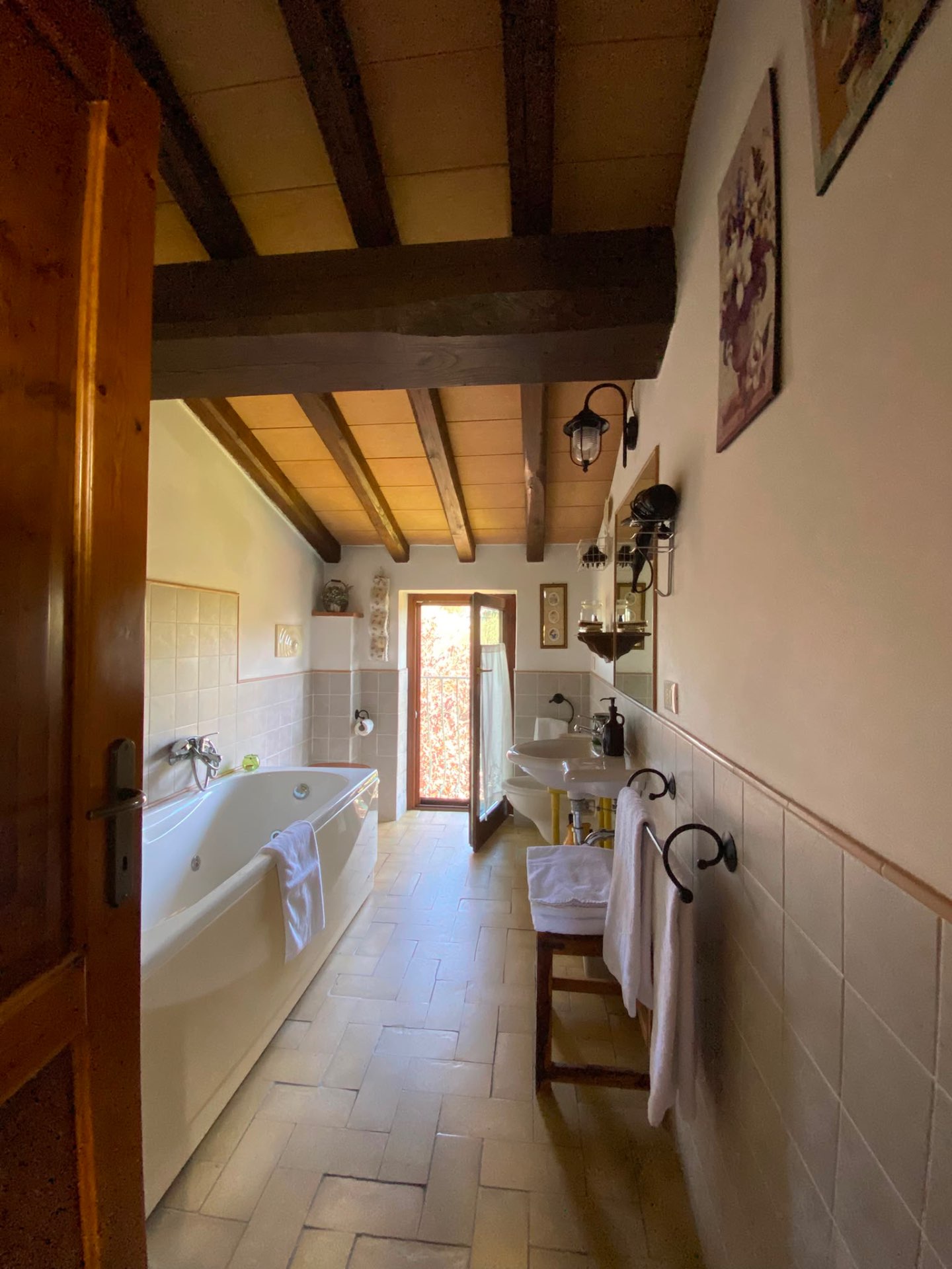 Bagno della Camera Margherita con vasca, lavabo e travi a vista